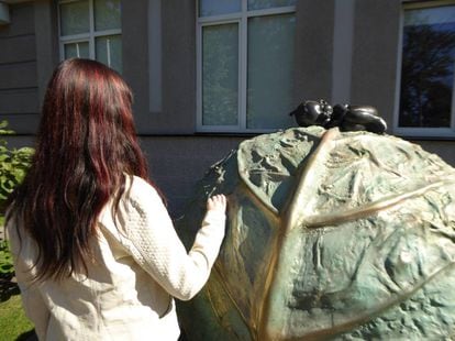 A surrogate mother in Kiev with a sculpture representing the legend that babies come from cabbages.