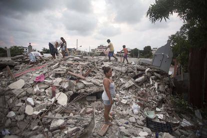 Survivors of Saturday's earthquake stand amid the ruins of their homes.