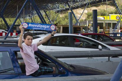 A boy holds up a sticker that reads &quot;I refuse to pay&quot; during a protest in Catalonia over toll roads.
