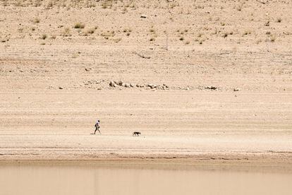A man walks where there was once water in the Entrepeñas reservoir in the Castilla–La Mancha region.