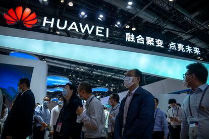 Visitors walk past a booth for Chinese technology firm Huawei at the PT Expo in Beijing on Sept. 28, 2021.