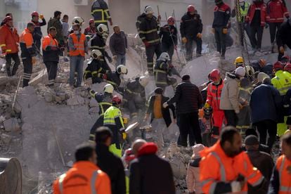 Firefighters and rescue teams search for people in a destroyed building, in Adana, southern Turkey, on Wednesday.