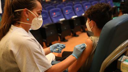 A health worker vaccinates a teenager in Madrid in August.