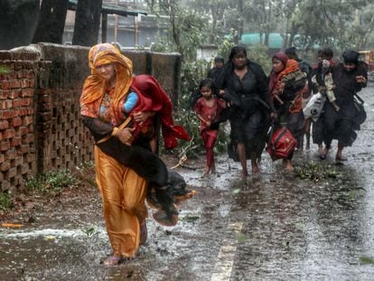 People move from their homes to take shelter in the nearest cyclone shelter at Shah Porir Dwip during the landfall of cyclone Mocha in Teknaf, Bangladesh, May 14, 2023.