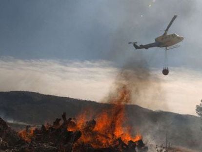 A helicopter flies over a burning fire in the Valencia province on Monday.