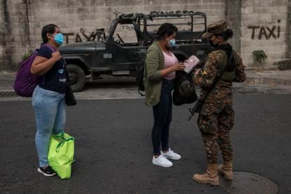 A soldier registers women entering the community of San José del Pino, El Salvador.