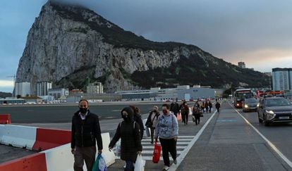 People walking along the Gibraltar airport runway to reach the border with Spain.
