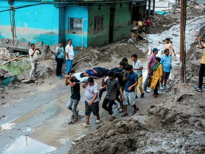 People carry a woman on a stretcher in an area affected by floods, in Teesta Bazaar, Kalimpong District, West Bengal, India October 7, 2023.
