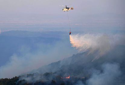 A firefighting helicopter drops water during efforts to put out wildfire in the area of Leptokarya, Evros, northern Greece, 26 August 2023 (issued 27 August 2023).