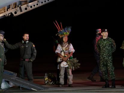 Military personnel and Indigenous leaders stand under a plane after the arrival of four siblings found after 40 days in the jungle.