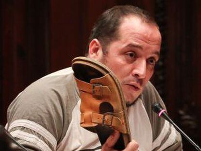Albert Fernández brandishes his shoe during the hearing.