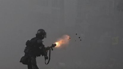 A police officer using tear gas against protesters marching against tax reform in Cali.