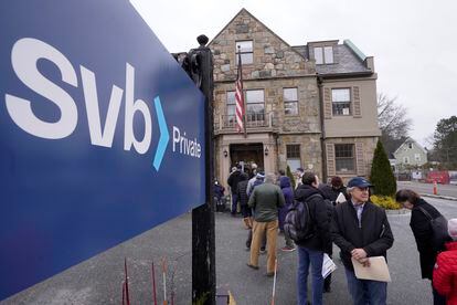 Customers and bystanders form a line outside a Silicon Valley Bank branch location, on March 13, 2023, in Wellesley, Massachusetts.
