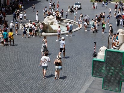 People spend time near Fontana della Barcaccia, at the Piazza di Spagna, during a heatwave across Italy