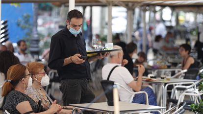 A waiter serves customers at a sidewalk café in L'Hospitalet, Barcelona.