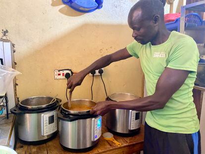 Bernard Okaal cooks with crockpots in his restaurant near Nairobi, Kenya, on September 8, 2023.