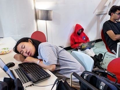 A participant sleeps at her computer during a ‘hackathon’ event organized in San Fransisco by the company Shirts.io.