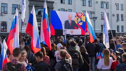 Local people watch a live broadcast of Russian President Vladimir Putin's annexation speech in Luhansk, Ukraine, 30 September 2022.