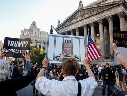 Anti-Trump demonstrators hold up signs on the day of the start of the trial at a Manhattan courthouse in New York City, on October 2, 2023.