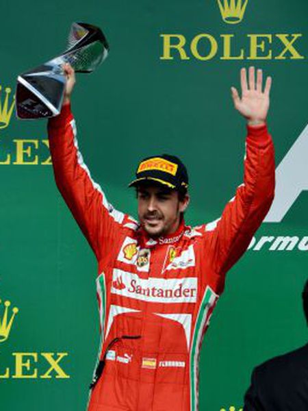 Second-place finisher Ferrari driver Fernando Alonso holds the trophy on the podium after the Canadian Grand Prix.