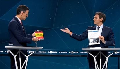 Pedro Sánchez offers Albert Rivera by Vox leader Santiago Abascal while Rivera pulls out a copy of Sánchez’s doctoral thesis.