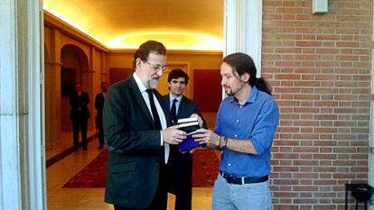 Pablo Iglesias presents Rajoy with a gift on his arrival at La Moncloa. 