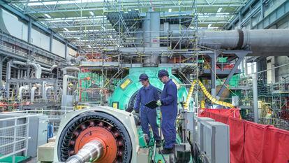Two engineers inspect generator machinery at a nuclear power plant during an outage.