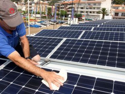 A worker installs solar panels at the Club Nautico de L'Estartit (Girona).