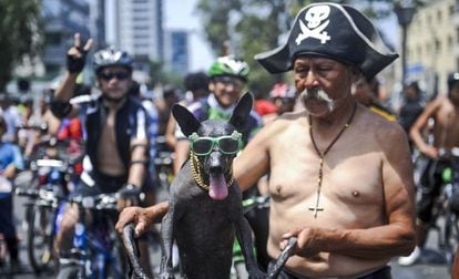 A man poses with his dog during a rally of nude cyclists in Lima, Peru.
