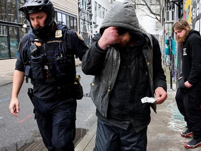 A police officer hands a citation to a fentanyl user in Portland (Oregon), on february 7.