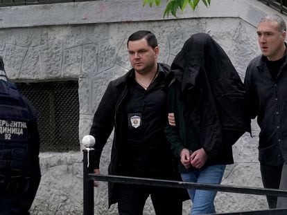 Police officers escort a minor, a seventh grade student who is suspected of firing several shots at a school in the capital Belgrade on May 3, 2023.