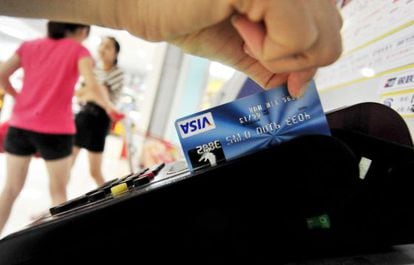 A shopper pays by credit card in a store.