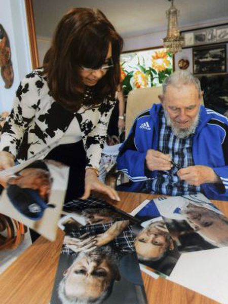 Cuba's former President Fidel Castro signs pictures for Argentinian President Cristina Fernández de Kirchner in Havana in this handout image.