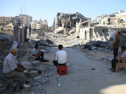 A group of Palestinians survey the destruction of Gaza City by Israeli bombings.