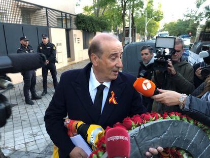 Francisco Franco Martínez-Bordiú, known as Francis Franco, the eldest grandchild of Spain’s former dictator Francisco Franco, talks to the media outside his home. He is carrying a wreath of flowers and a pre-constitutional flag.