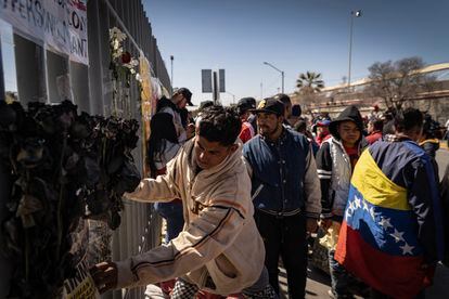 Migrants place flowers at a shrine dedicated to the men who died in Monday night's fire. 