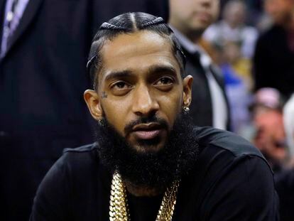 Rapper Nipsey Hussle attends an NBA basketball game between the Golden State Warriors and the Milwaukee Bucks in Oakland, Calif., March 29, 2018.