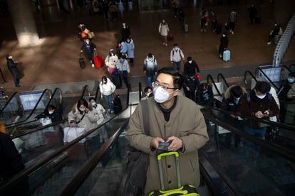 Travelers ride escalators at Beijing West Railway Station in Beijing, Wednesday, Jan. 18, 2023.