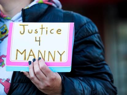 A protester holds a sign during a rally after the verdict was read during the trial of three Tacoma Police officers in the death of Manny Ellis, at Pierce County Superior Court, Thursday, Dec. 21, 2023, in Tacoma, Wash.