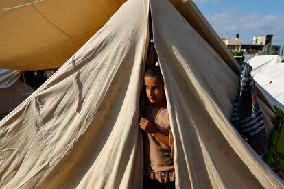 A girl peeks out of a tent in a refugee camp in Khan Yunis on October 20.