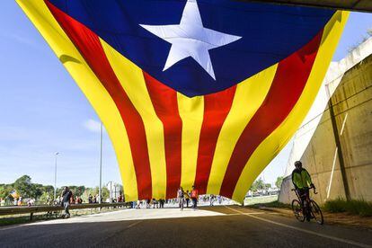 A large ‘estelada’ – the unofficial flag adopted by supporters of Catalan independence – is unfolded by protesters during a march along the N-11 highway in Vilobí d’Onyar (Girona).