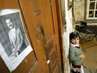 Lileana Khalil, 6, looks at a picture of Iraqi President Saddam Hussein in her bedroom in the Little Abu Newas neighborhood in Baghdad, Iraq, on January 30, 2003