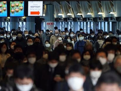 A station passageway is crowded with commuters wearing face mask during a rush hour on January 8, 2021, in Tokyo.