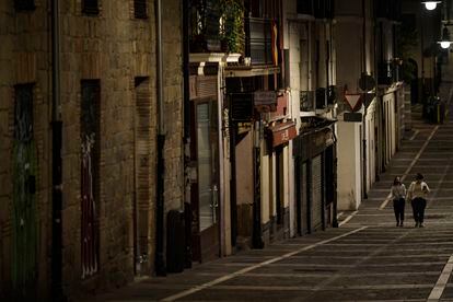 Residents wearing face mask walk along an empty street in Pamplona on October 24.