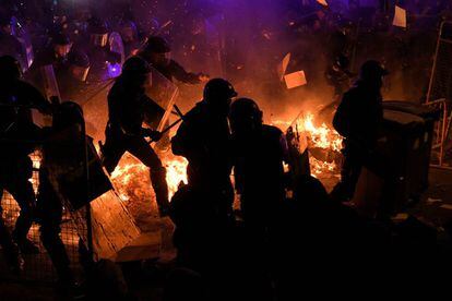 Protesters light fires during clashes with police in Barcelona.