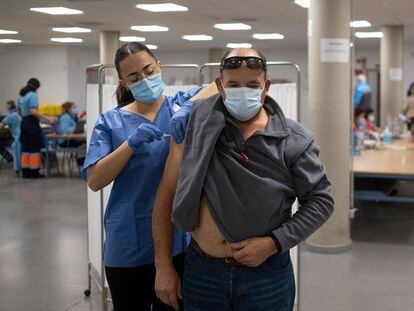 A man getting a Covid-19 booster at a vaccination point inside Seville University's School of Law. 
