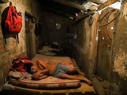 Cesar Velasquez, 14, lies on a mattress, while spending time with his cell phone, at his grandmother's house where he now lives, because his parents were detained during the government's crackdown on its war against drugs, in Santa Ana, El Salvador, Wednesday, Jan. 31, 2024.