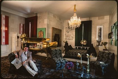 Alexander Iolas, pictured at his home in Athens, in 1983. In the background, there’s a sculpted bar in the shape of a cat, designed by Claude & François-Xavier Lallane.