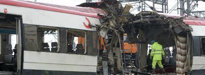 Investigators look at the damage the March 11, 2004 bomb blast caused to commuter train cars in Madrid the day after the tragedy.