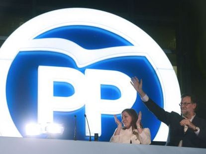 Prime Minister Mariano Rajoy waves next to his wife Elvira Fernandez at PP headquarters on Sunday night.